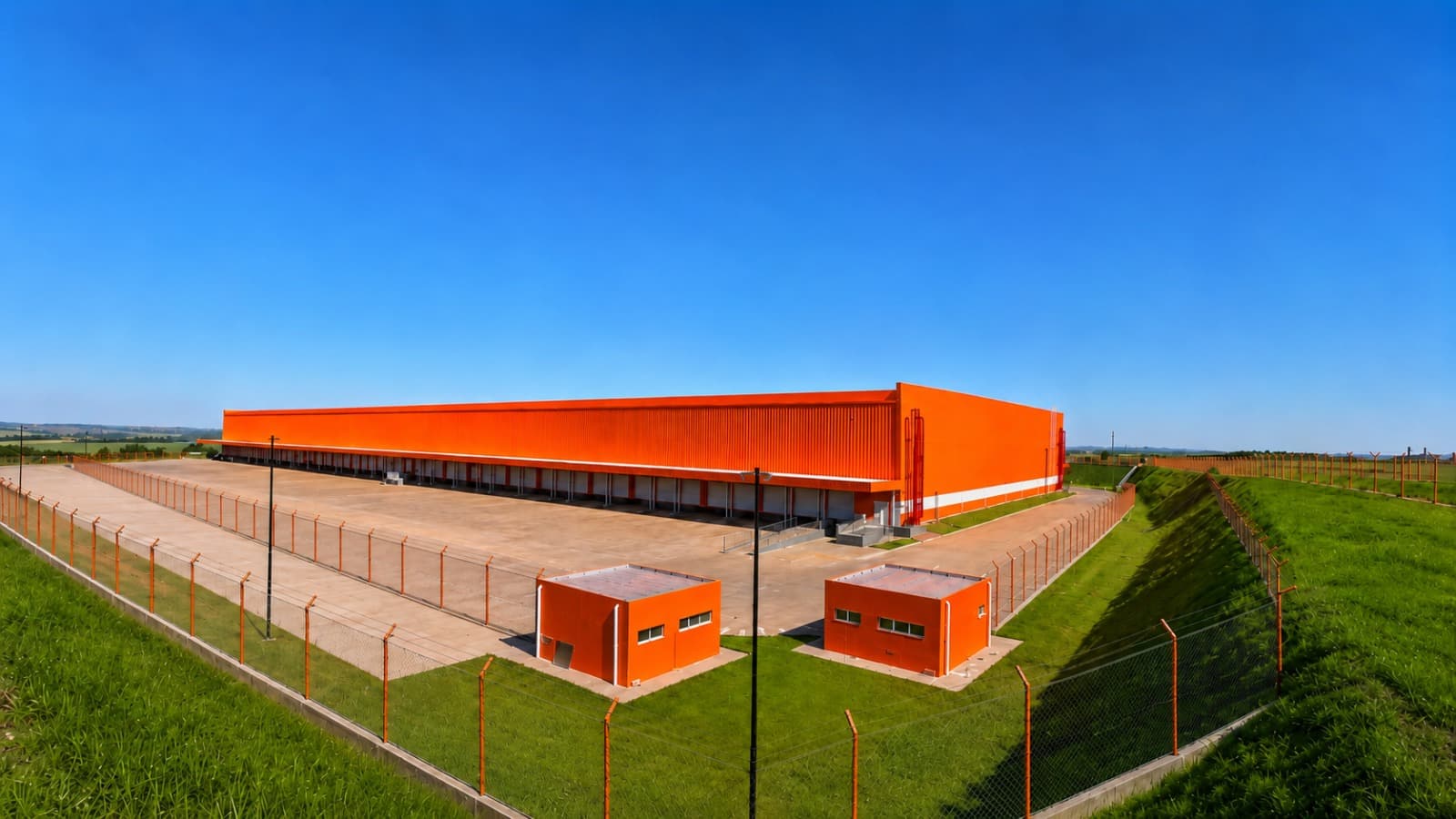 Centro de distribuição da Shopee, galpão laranja com pátio de manobras cercado